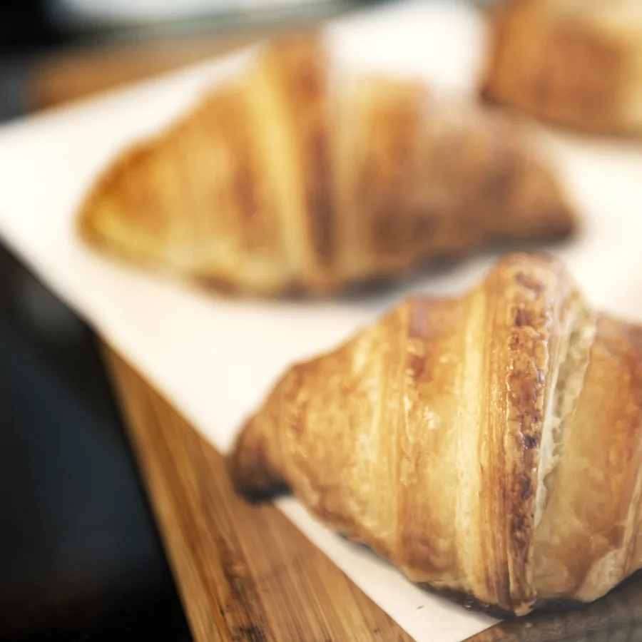 Butter croissants on baking paper and a wooden board.