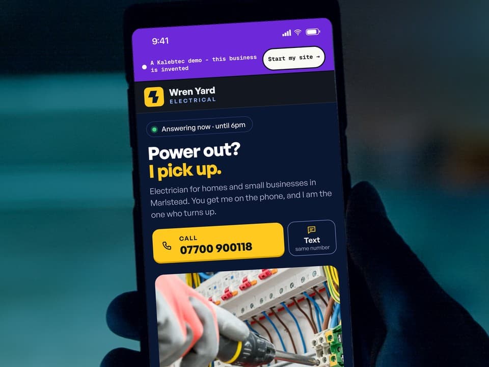 A phone open on the first screen of the Wren Yard Electrical demo: the headline "Power out? I pick up.", a yellow call button, and gloved hands at an open consumer unit.